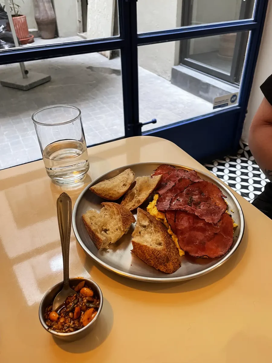 Plato de huevos revueltos con pastrami artesanal y café de especialidad en Poga Cafelicatessen, colonia Cuauhtémoc, CDMX.
